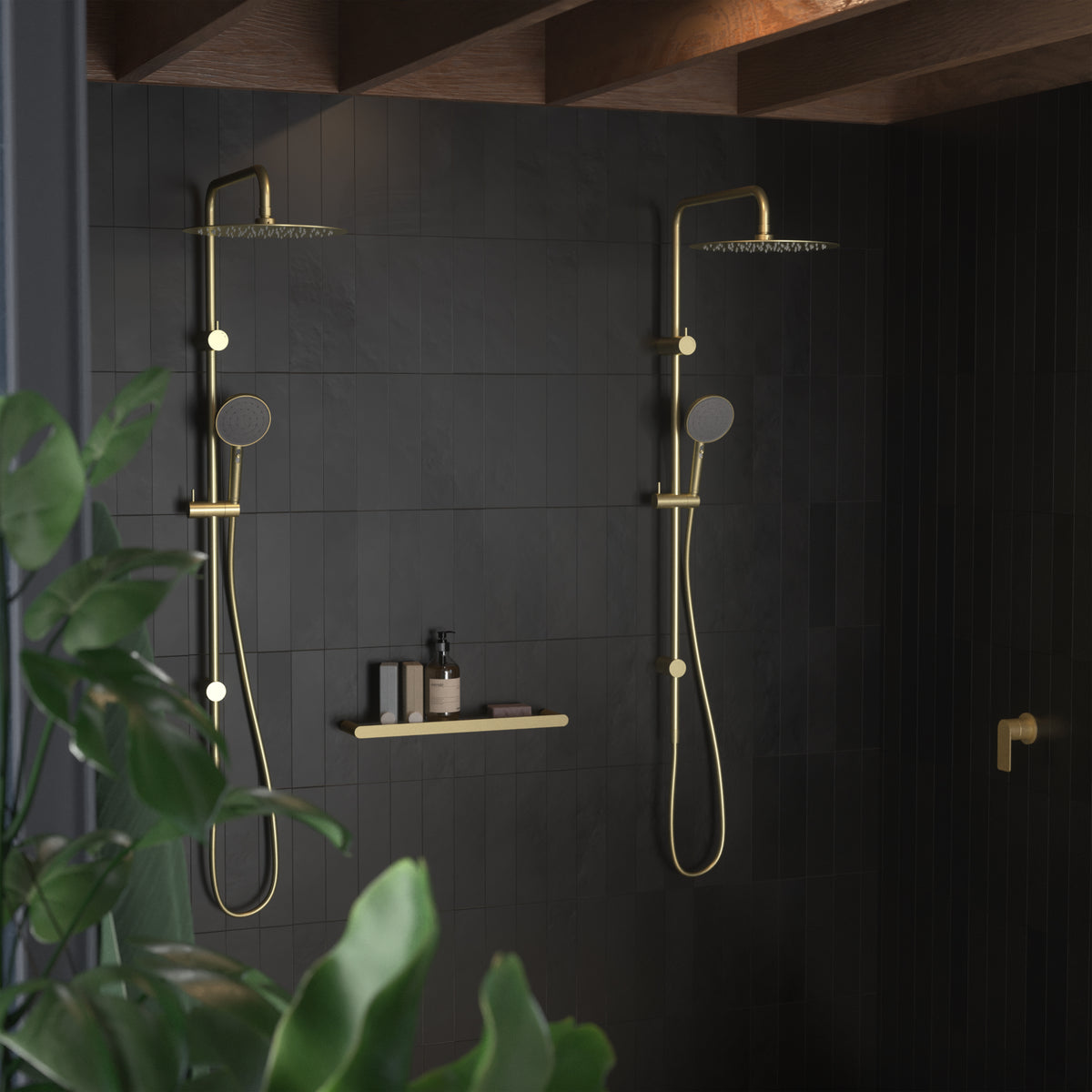 Two Caroma Urbane II rail showers in brushed brass against a dark tiled bathroom wall.
